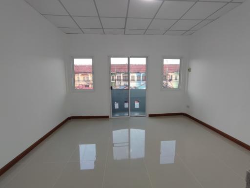 Spacious empty room with glossy tiled floor and large windows