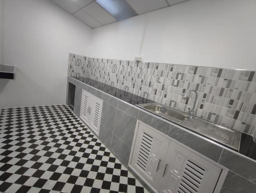 Spacious kitchen with monochrome checkered floor and modern cabinets