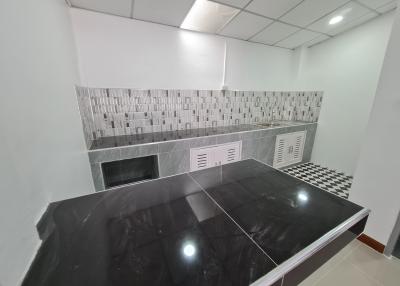 Modern kitchen interior with black countertops and white tiled walls