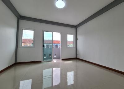 Spacious and well-lit empty living room with clean tile flooring and multiple windows
