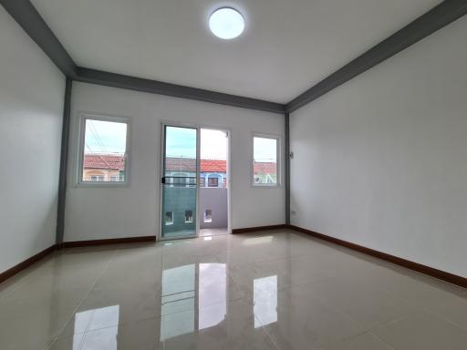Spacious and well-lit empty living room with clean tile flooring and multiple windows