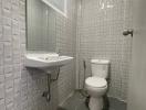 Compact tiled bathroom with wall-mounted sink and toilet