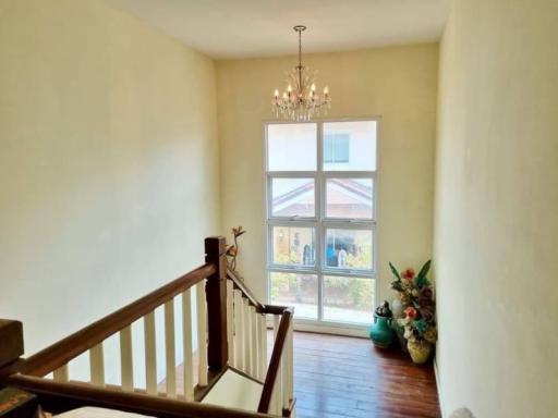 Bright hallway with chandelier and large window