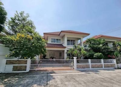 Spacious two-story house with a gated entrance and lush greenery