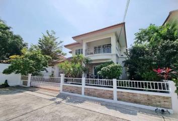 Residential two-story house with white fence and driveway