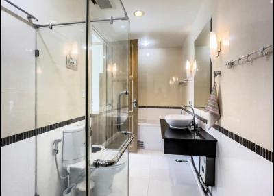 Modern spacious bathroom with glass shower enclosure and white fixtures