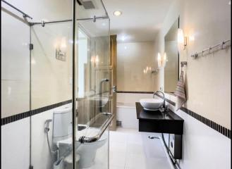 Modern spacious bathroom with glass shower enclosure and white fixtures