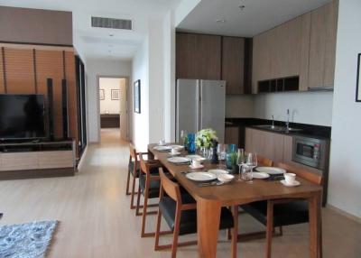 Modern dining area with adjacent kitchen equipped with stainless steel appliances