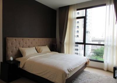 Contemporary bedroom with queen-sized bed and city view
