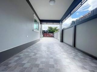 Spacious covered parking or patio area with tiled flooring and bright lighting