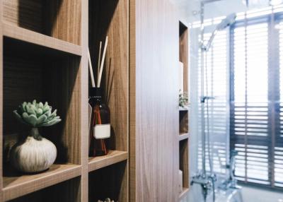 Modern bathroom interior with a wooden shelf and decorative elements