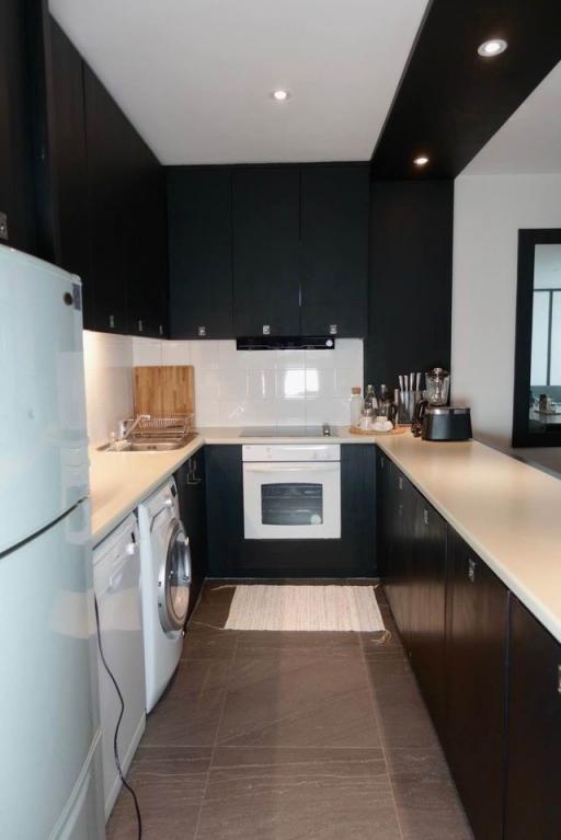 Modern kitchen with black cabinetry and integrated appliances