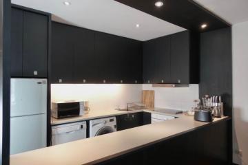 Modern kitchen with black cabinetry and stainless steel appliances