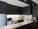 Modern kitchen with black cabinetry and stainless steel appliances