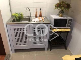 Compact kitchen with basic appliances and wooden cabinetry