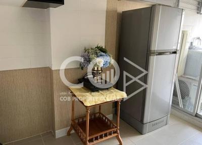 Small kitchen space with large fridge and wooden table