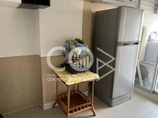 Small kitchen space with large fridge and wooden table