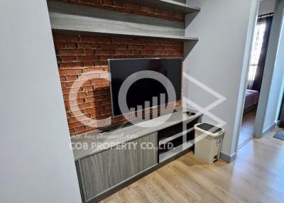 Modern living room with exposed brick feature wall and wooden flooring