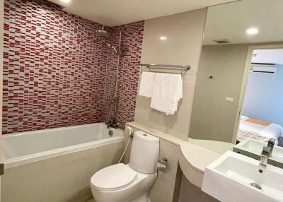 Modern bathroom with mosaic tile wall and white fixtures