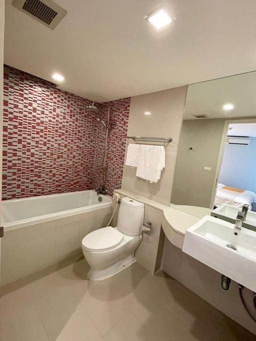 Modern bathroom with mosaic tile wall and white fixtures