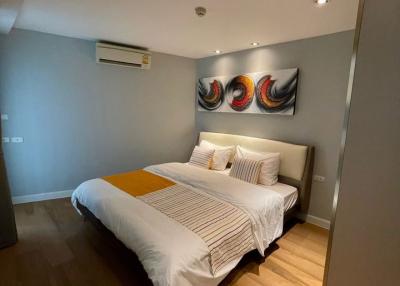 Modern bedroom with queen-sized bed and artistic wall decor