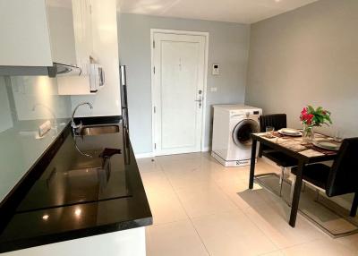 Modern kitchen with dining area featuring stainless steel appliances and front load washer