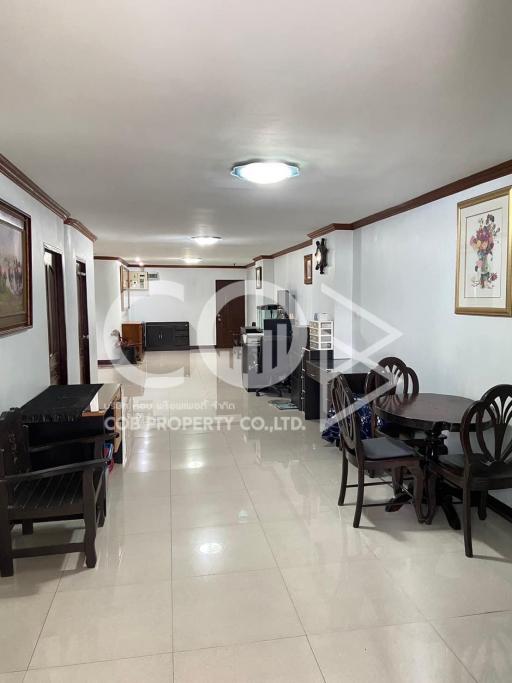 Spacious and well-lit living area with dining set and glossy tiled flooring