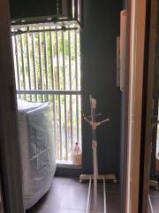 Laundry area with a closed washing machine and natural light