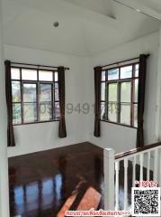 Empty well-lit bedroom with shiny wooden floor and open windows