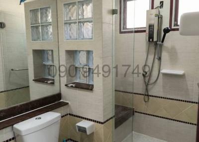 Modern bathroom interior with tiled walls, shower, and toilet