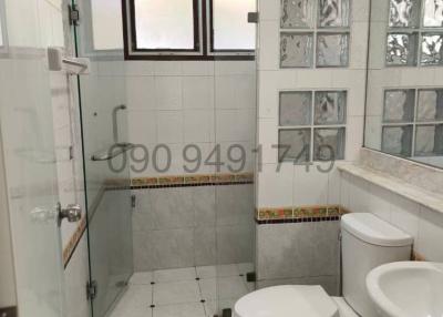 Modern bathroom interior with a shower stall, toilet, and decorative tilework