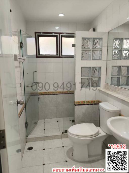 Modern bathroom interior with a shower stall, toilet, and decorative tilework