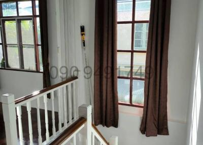 Bright staircase area with white railing and hardwood floors