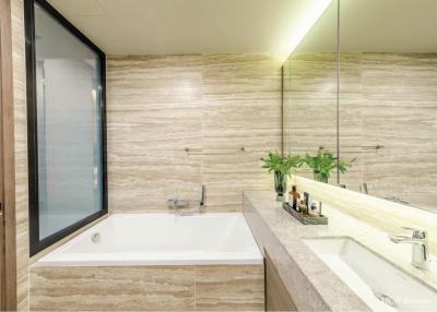 Modern bathroom with natural stone tiles and large mirror