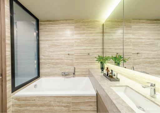 Modern bathroom with natural stone tiles and large mirror