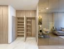 Elegant entrance area with wooden shelves, sliding door, and a glimpse into the dining and living space