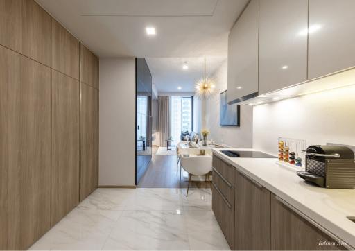 Modern kitchen with marble flooring extending to an open dining area with ample natural light