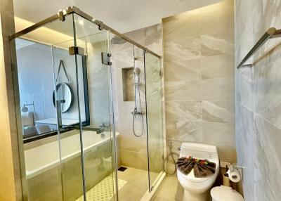 Modern bathroom with glass shower enclosure and marble walls