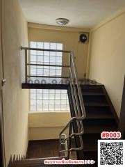 Modern staircase interior with metal banisters and large window