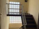 Modern staircase interior with metal banisters and large window