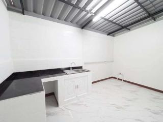 Spacious kitchen with modern design, black countertops, and white cabinetry