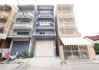 Modern multi-story residential building with balconies and garage