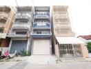 Modern multi-story residential building with balconies and garage