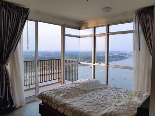 Spacious bedroom with large windows providing a panoramic city view