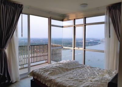 Spacious bedroom with large windows providing a panoramic city view