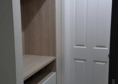 Compact bedroom interior with built-in wardrobe and white door