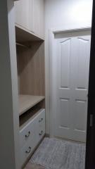 Compact bedroom interior with built-in wardrobe and white door