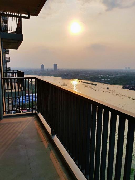 Spacious balcony with scenic sunset view over the water