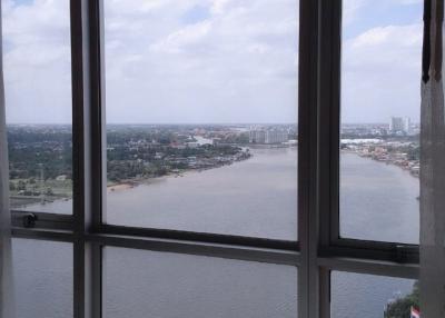 High-rise building view featuring a large window with a panoramic view of a cityscape and river