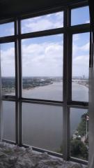 High-rise building view featuring a large window with a panoramic view of a cityscape and river